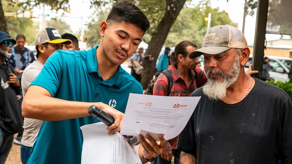 man requesting attention of another to a piece of paper