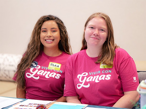 Two women in pink shirts smiling