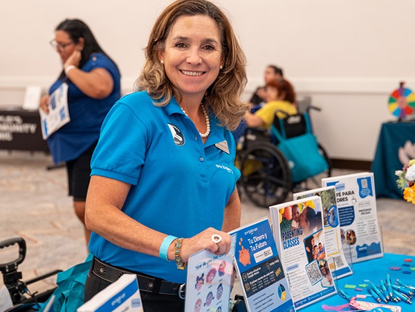 woman in a blue shirt standing at a vendor table